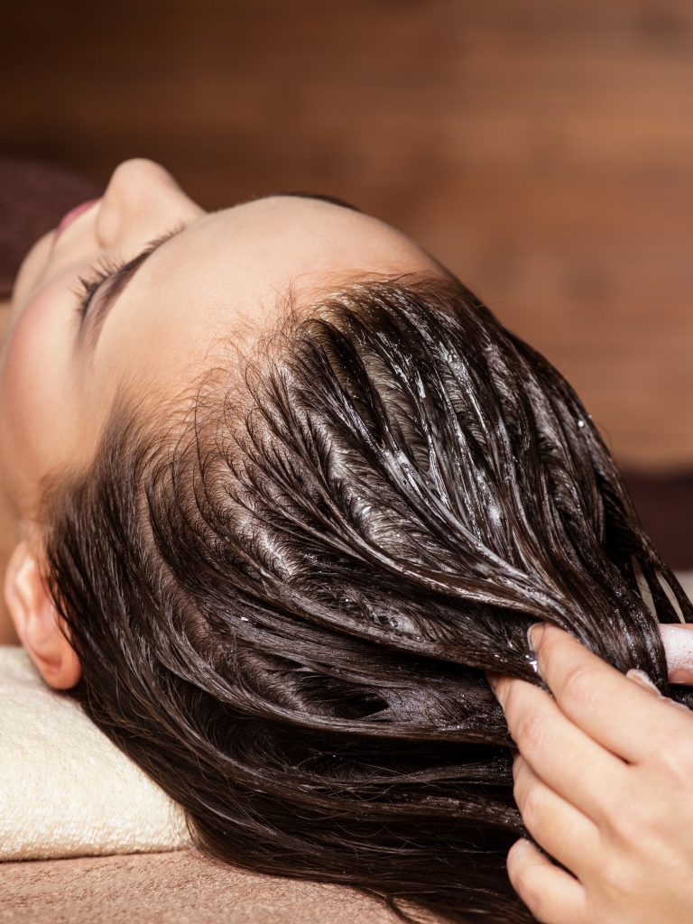 massaging hair with coconut oil