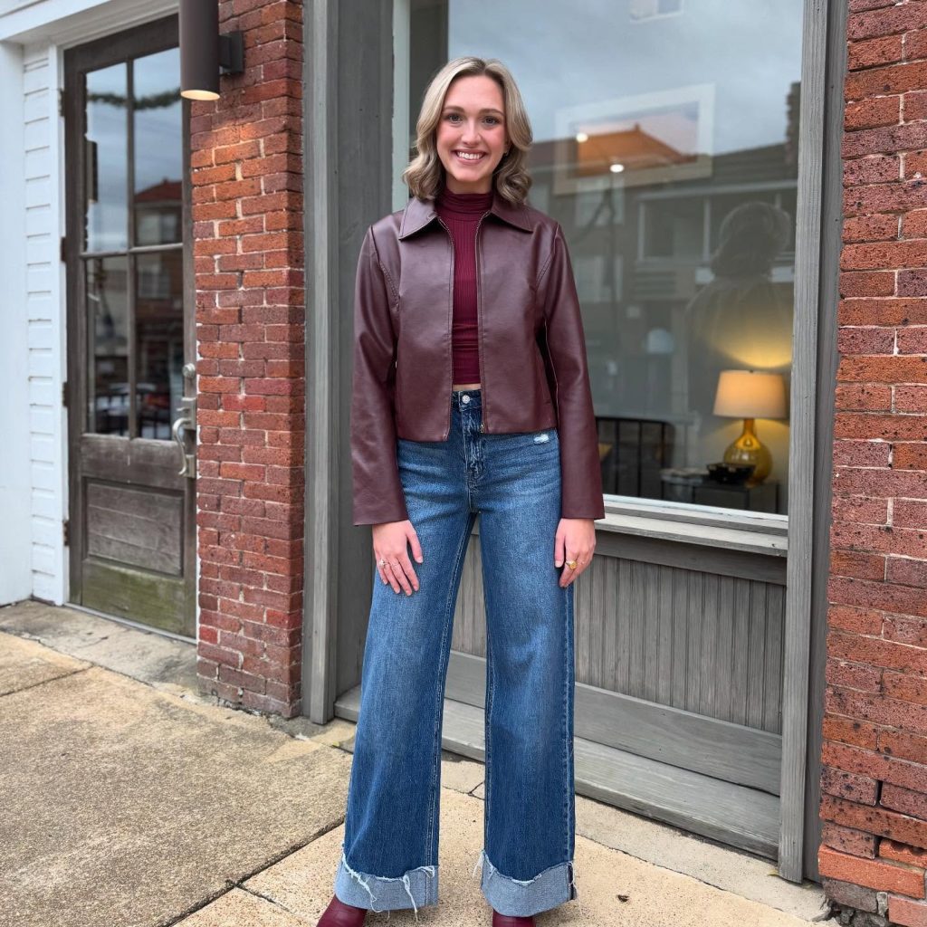 Burgundy leather jacket with dark cuffed jeans