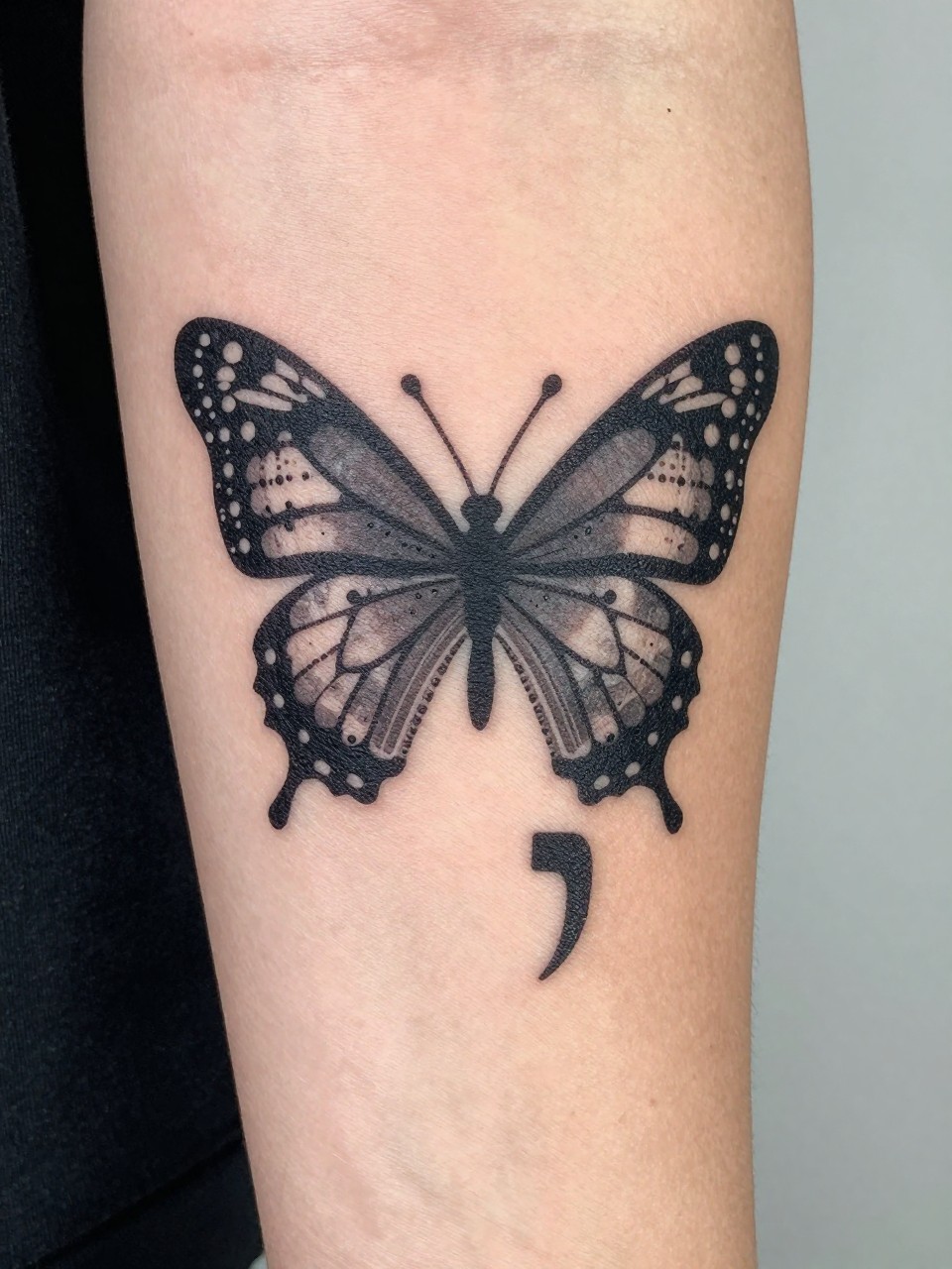 "Close-up of the outer arm: a butterfly and semicolon silhouette formed entirely from precise Morse code dots and dashes. Geometric and deeply personal."
