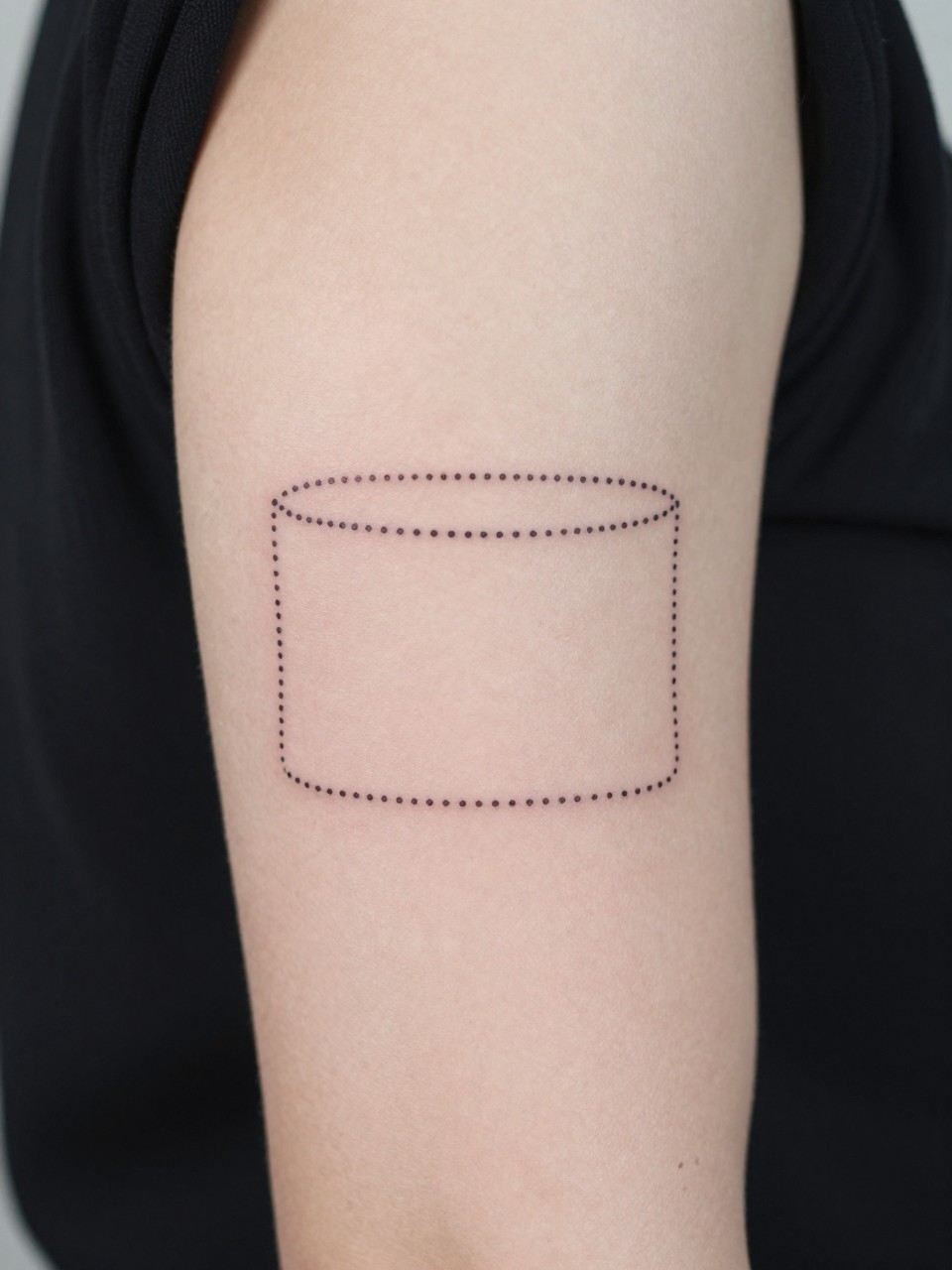 Image Prompt: "Close-up of a negative space cuff tattoo on an upper arm. Dotted outlines form the shape, with bare skin in the middle. Soft, even lighting. Clean and minimalist aesthetic with a focus on the design concept."