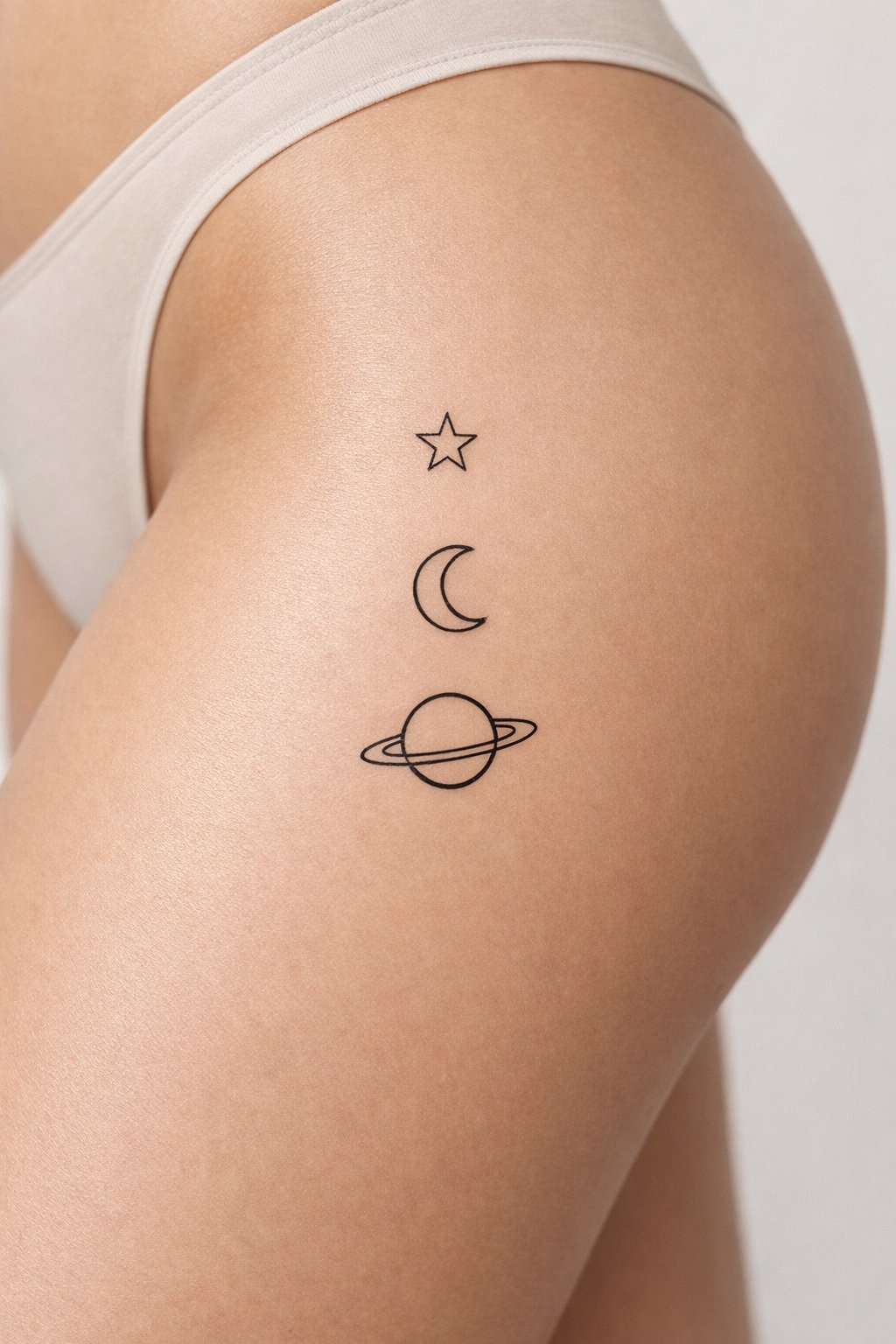 Side thigh line-up: a small star, a crescent moon, and Saturn aligned vertically. Each element is simple, outlined, and spaced evenly apart