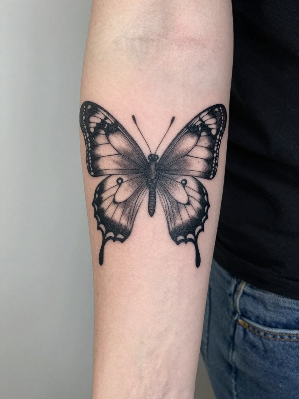 "Detailed section of a sleeve: a butterfly’s wing tattoo. Fine linework, subtle grey shading. Focus on the seamless, storytelling integration."