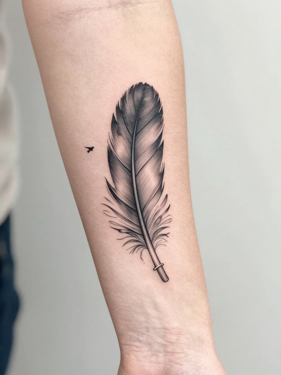 "close-up of a black crow feather tattoo transforming into small birds on the forearm, black ink, fine line and soft shading, elegant movement, realistic skin texture, delicate ring, minimal soft background, feminine tattoo inspiration photography, design-focused composition (no watermarks on images)"