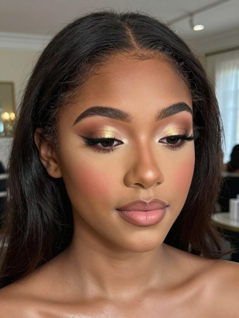 IMAGE_PROMPT: Super realistic close-up beauty portrait of a black  teen girl wearing classy soft glam prom makeup, featuring warm beige and tan eyeshadow, softly deepened brown outer corners, bright gold inner-corner glow, lengthened lifted lashes, peachy nude blush, satin nude pink lips, polished brows, realistic skin texture with a smooth warm glow, shot from a front-facing beauty portrait, with soft elegant lighting that clearly reveals the gold inner-corner highlight, neutral eye detail, and satin lips, softly curled hair, blurred upscale ballroom background, feminine modern beauty photography, latest iPhone photo quality.