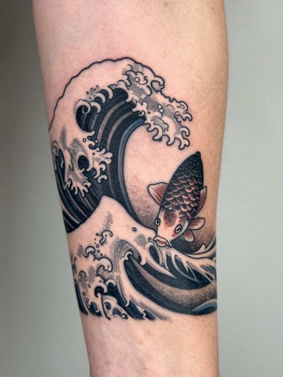 macro shot of a clean Japanese wave and koi starter tattoo on the forearm, small koi fish moving through bold wave forms, black and grey ink, crisp traditional linework, soft shading, realistic skin texture, tight crop, design-first tattoo image, soft neutral background, tattoo inspiration image (no watermarks on images)