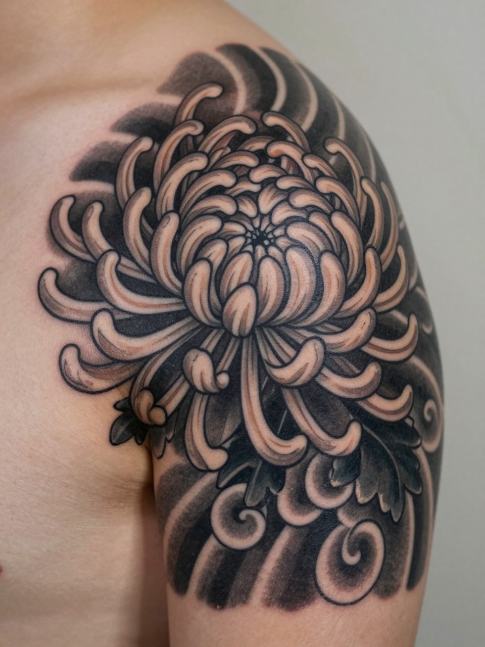 macro shot of a Japanese chrysanthemum and cloud tattoo on the shoulder, layered flower petals with bold cloud filler, black and grey ink, crisp traditional linework, soft shading, realistic skin texture, design-first composition, soft neutral background, tattoo inspiration image (no watermarks on images)