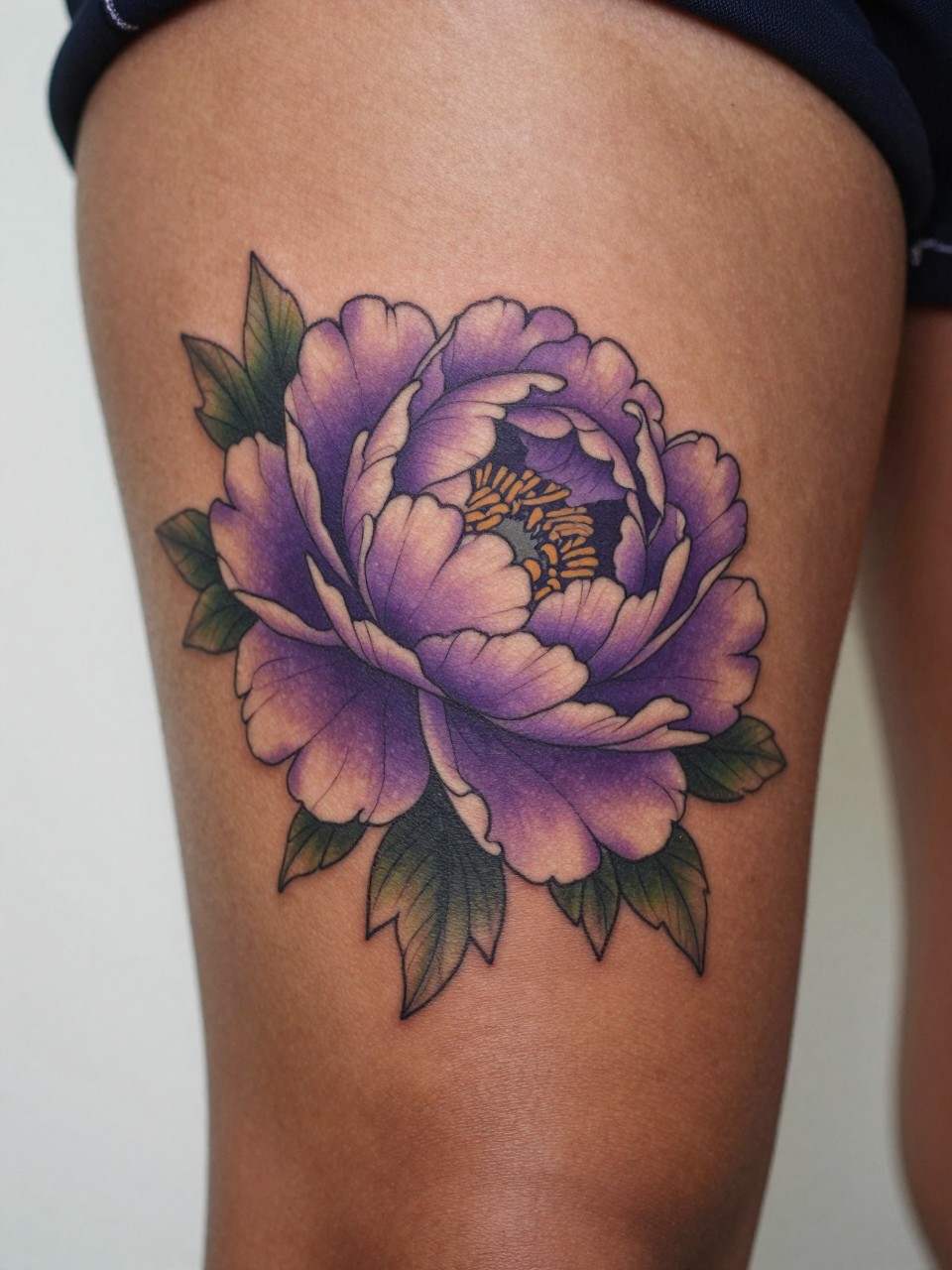 extreme close-up of a purple and pink peony tattoo on deep brown skin at the thigh, layered petals, soft blended color, dark clean outline, realistic skin texture, satin slip edge visible, soft minimal background, design-focused feminine tattoo inspiration photography (no watermarks on images)