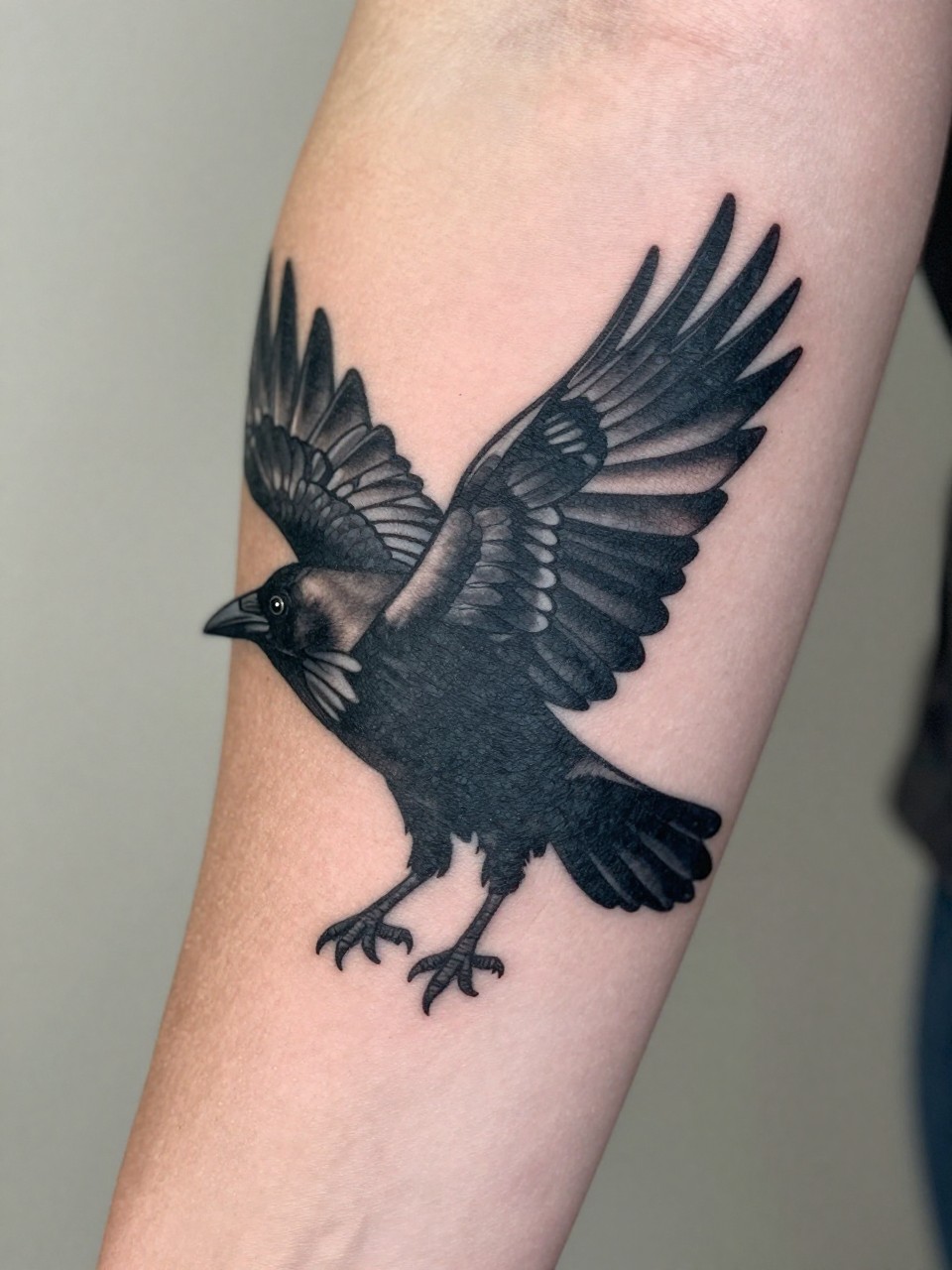  "extreme close-up of a black crow silhouette tattoo in flight on the forearm, wings fully spread, deep black ink, clean sharp linework, minimal shading, design-focused close-up, realistic skin texture, soft feminine lifestyle detail with delicate ring, neutral blurred background, modern tattoo inspiration photography (no watermarks on images)"