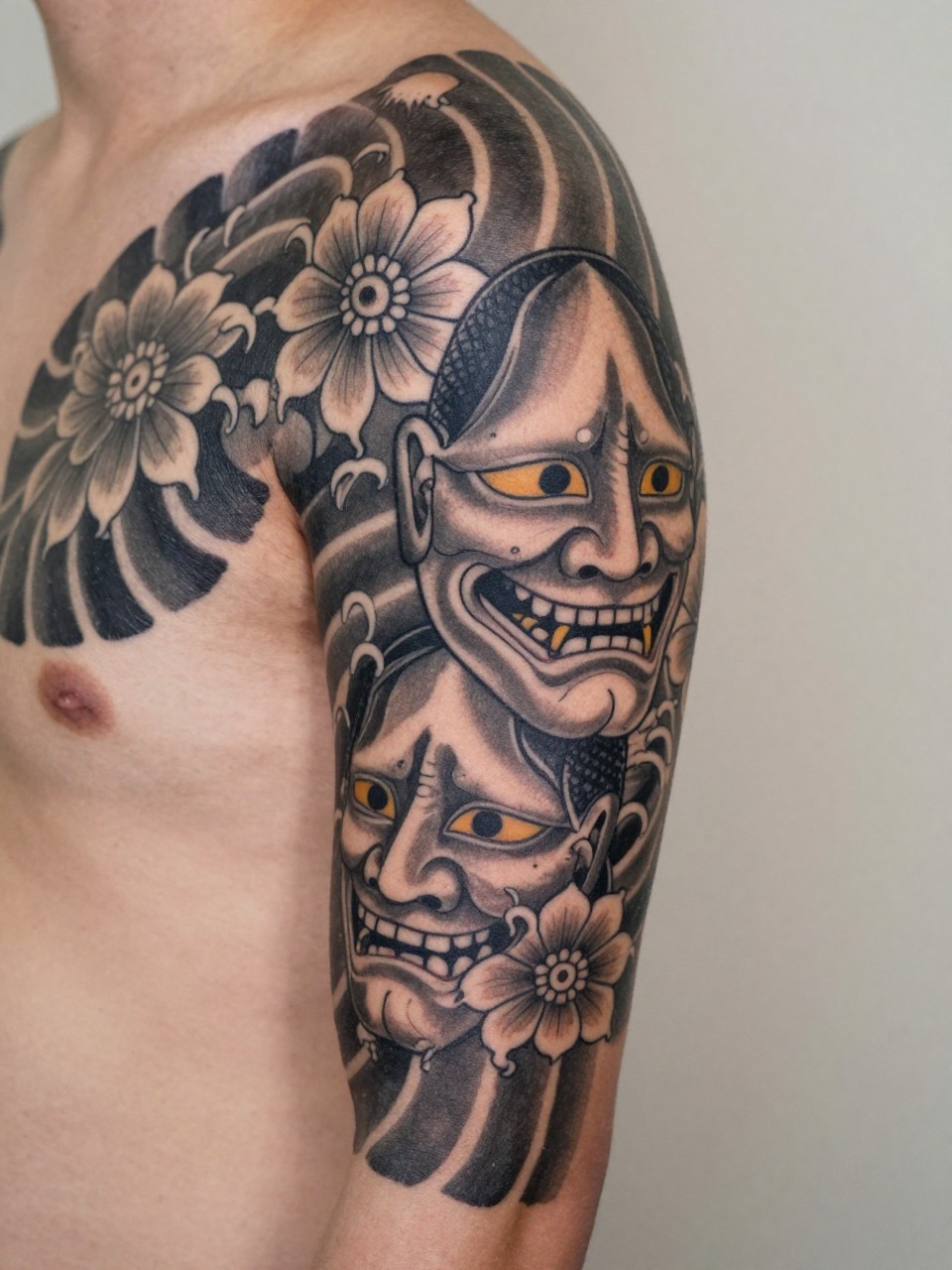 macro shot of a blackwork traditional Japanese sleeve tattoo on the arm, mixed waves flowers serpent and mask elements, heavy black ink, strong contrast, bold traditional-inspired linework, realistic skin texture, design-first tattoo image, soft neutral background, tattoo inspiration image (no watermarks on images)