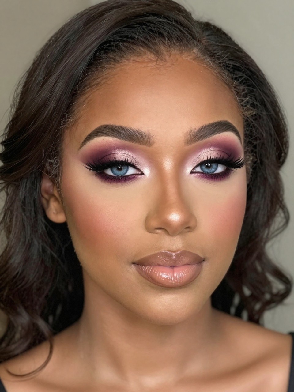 IMAGE_PROMPT: Super realistic close-up beauty portrait of a black young woman with blue eyes wearing lovely prom makeup, featuring mauve and soft plum smoky eyeshadow with taupe-brown blending, brown-plum liner, full fluttery lashes, muted rose blush, warm nude beige glossy lips, softly luminous skin texture, shaped brows, shot from a three-quarter portrait angle, with romantic diffused evening lighting that clearly reveals the mauve smoke, blue eyes, and glossy lips, softly curled prom hairstyle, blurred dreamy formal background, feminine modern beauty photography, latest iPhone photo quality.