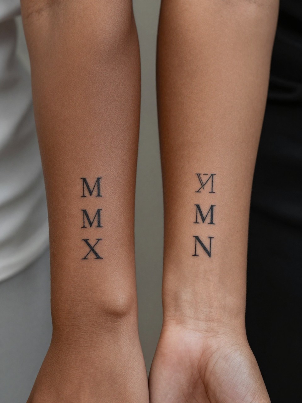 "design-focused close-up of matching Roman numeral tattoos on rich brown skin, one on each forearm, clean black ink, fine line lettering, minimalist elegant style, realistic skin texture, soft blurred background, modern tattoo inspiration photo (no watermarks on images)"