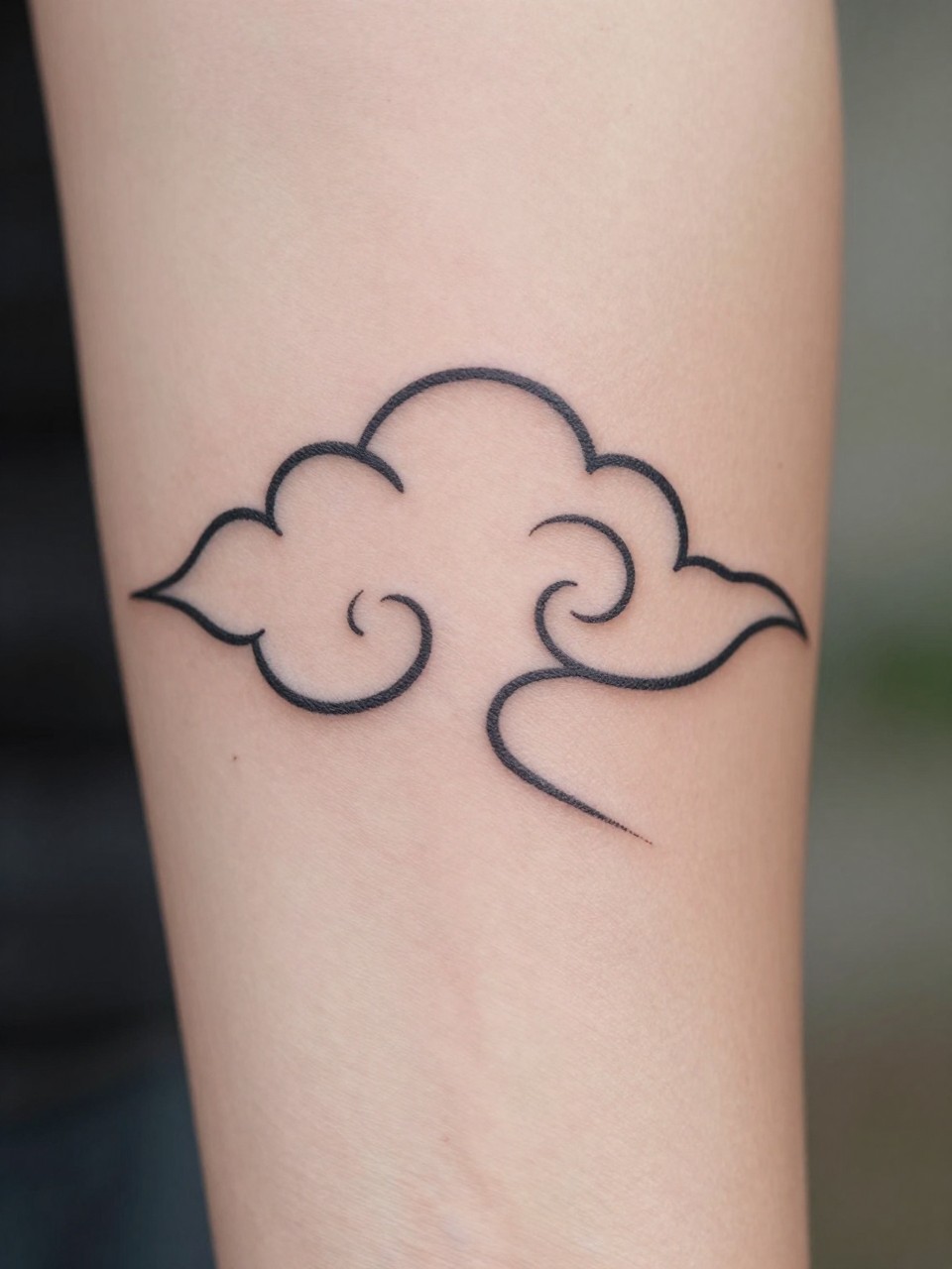 close-up of a minimal Japanese cloud outline tattoo on the inner arm, crisp black ink, clean traditional cloud curves, almost no shading, minimalist composition, realistic skin texture, design-focused close-up, blurred neutral background, modern tattoo photography (no watermarks on images)