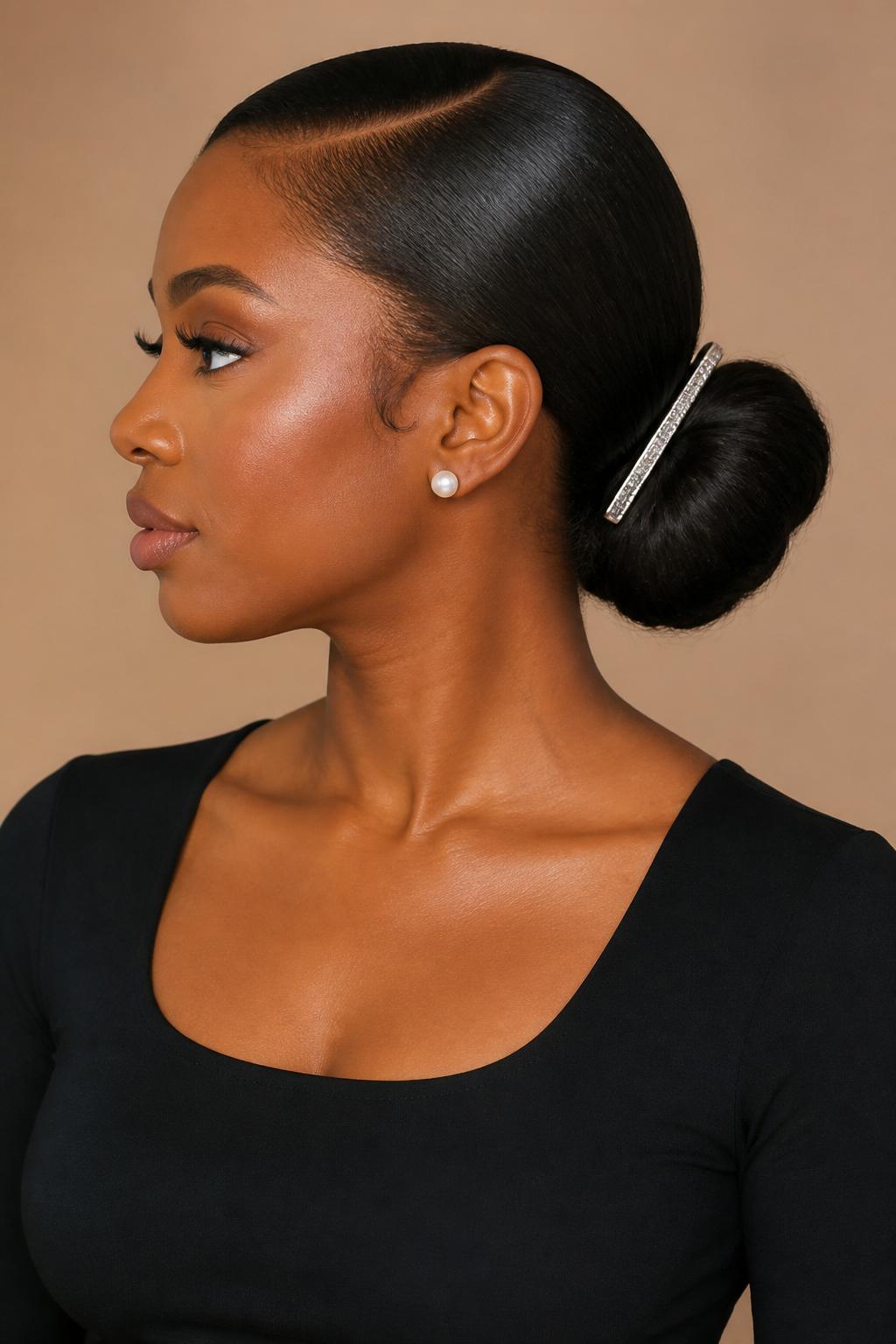 Image Prompt:
A realistic editorial hairstyle photo of a black woman with medium-length silk-pressed hair styled into a sleek low bun secured with a long silver French clip placed across the bun, clean side part, glossy smooth finish, warm brown skin, pearl earrings, black fitted top, soft beige studio background, polished modern hairstyle inspiration, high-resolution DSLR photo, no text, (no watermarks on images)