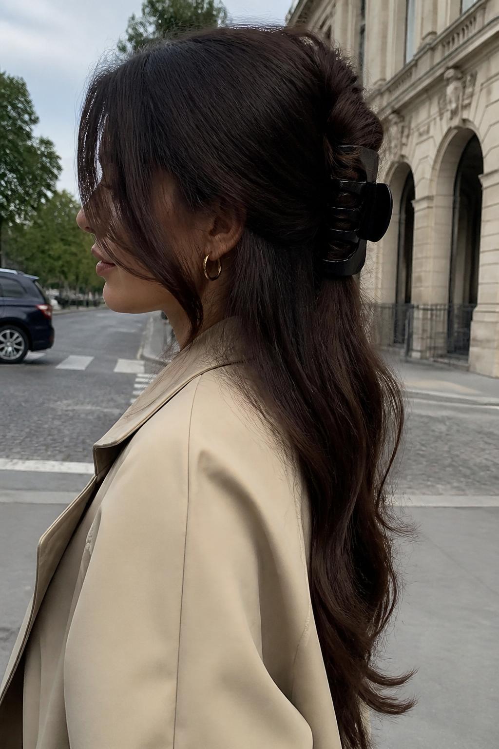Image Prompt:
A realistic side-view hairstyle photo of a woman with very long dark brown hair styled into a banana twist with a large black claw clip, hair twisted vertically with the ends flowing down from the top, smooth but slightly relaxed texture, beige trench coat, city street background, soft cloudy daylight, stylish everyday hair inspiration, editorial DSLR photo, no text, no watermark.