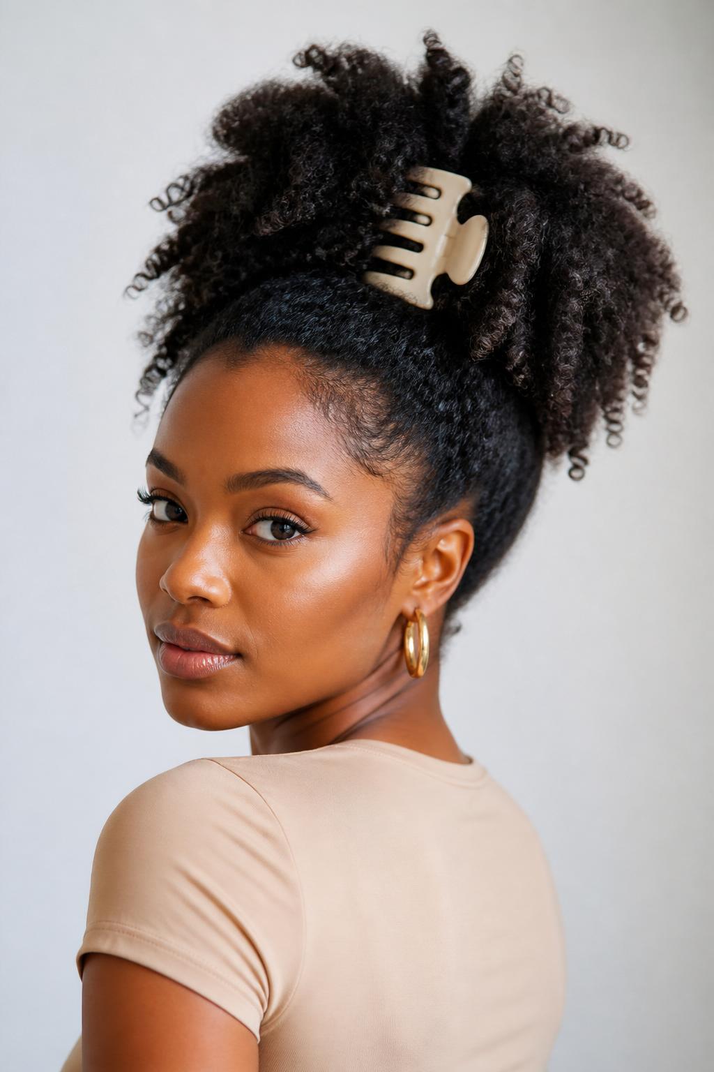 Image Prompt:
A realistic beauty portrait of a black woman with natural curly hair styled into a high claw clip puff, curls gathered upward and secured with a large matte cream claw clip, full textured puff shape, soft edges, warm brown skin, gold hoop earrings, fitted beige top, clean bright studio background, modern natural hair inspiration, high-resolution DSLR quality, no text, (no watermarks on images)
