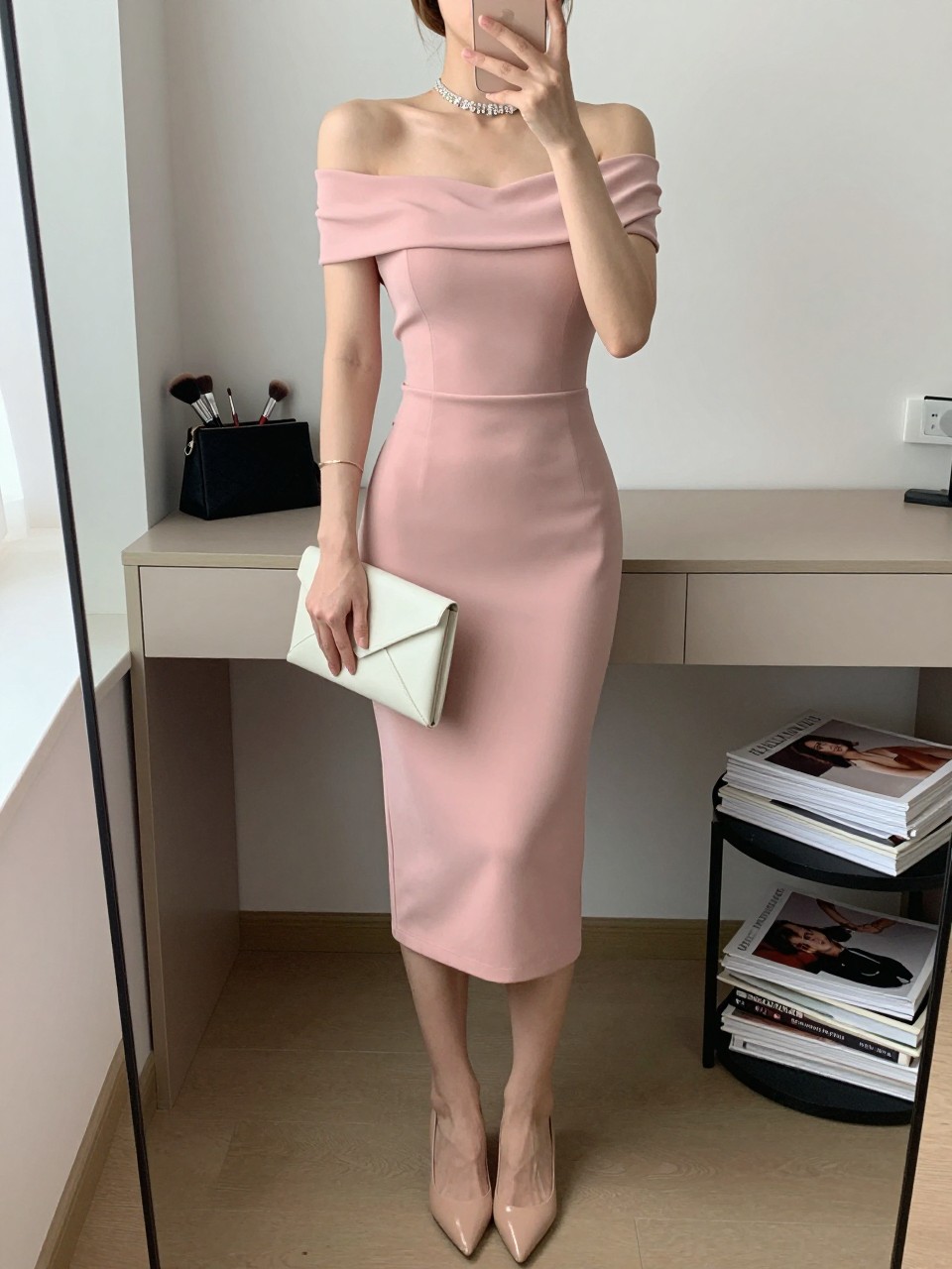 Image Prompt

mirror selfie of a woman wearing a soft pink off-shoulder fitted midi dress, nude pointed-toe pumps, delicate crystal choker, ivory envelope clutch, and polished updo with soft highlighter, clearly showing the same clothing items, colors, fabrics, and accessories listed in the Outfit Pieces section, holding a phone in front of a mirror, cropped at NECK so the face does not show, with a relaxed casual selfie pose, in a minimal dressing room, natural window light, including a makeup brush or cosmetic bag on the counter and stack of fashion magazines on a side table, latest iPhone photo quality.