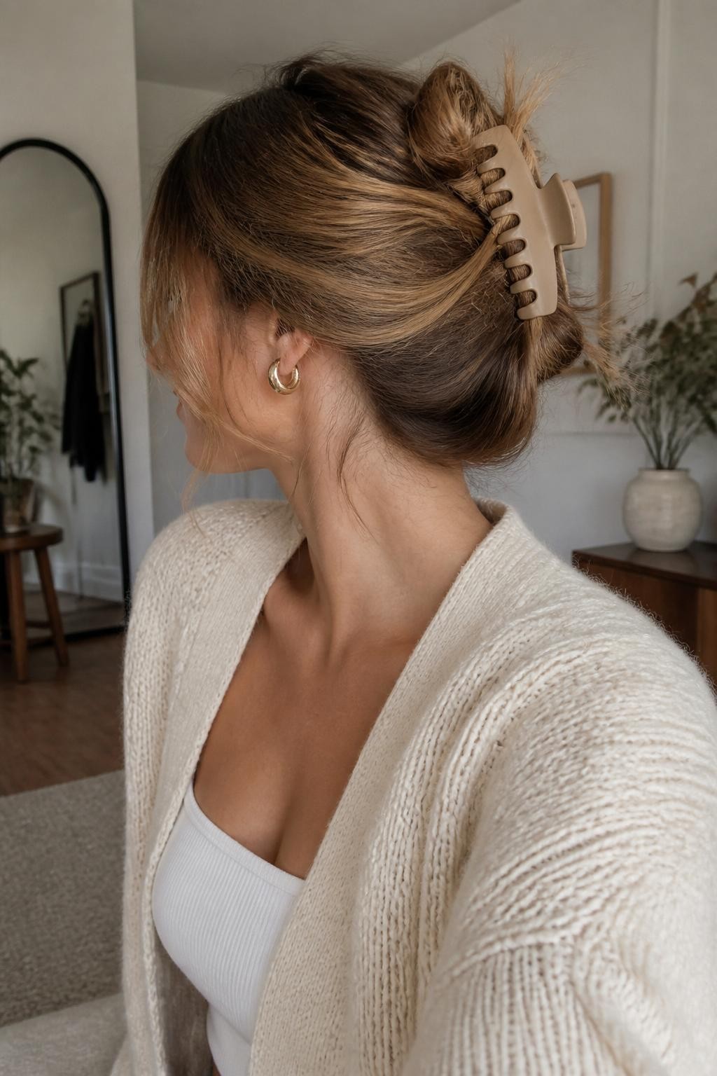 Image Prompt:
A realistic casual beauty photo of a woman with medium-length dark blonde hair styled into a messy banana clip bun, loose twisted hair secured with a matte beige banana clip, wispy layers around the face and neck, oversized cardigan, relaxed home background, morning natural light, cozy everyday hairstyle inspiration, high-resolution DSLR photo, no text, (no watermarks on images)