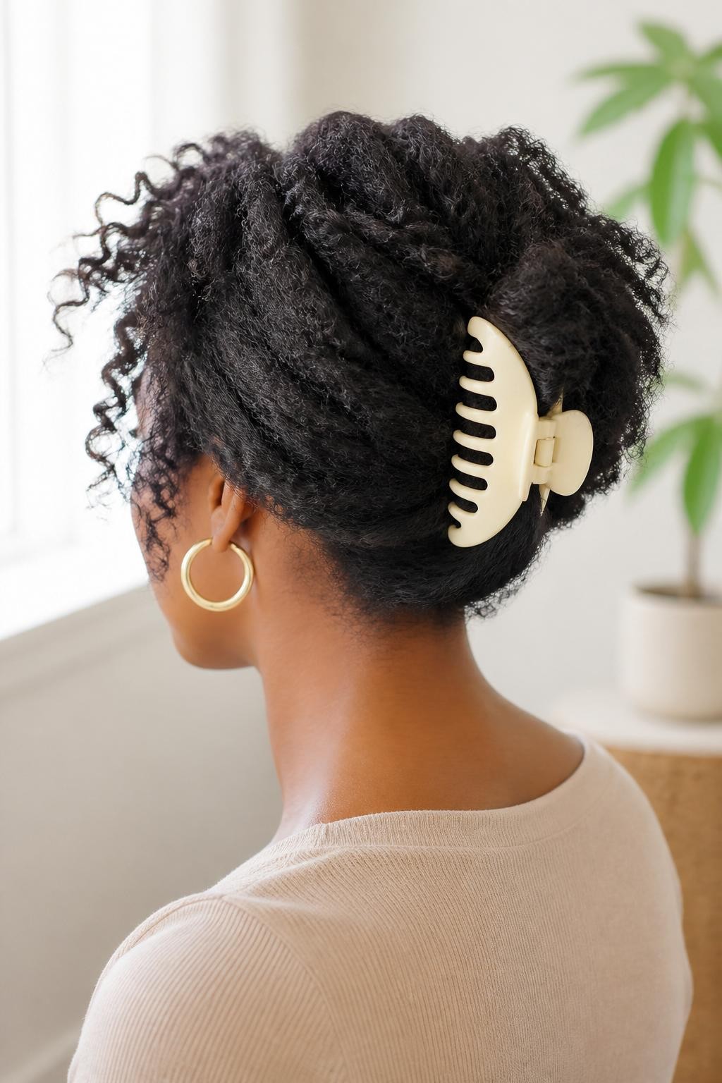 Image Prompt:
A realistic hairstyle photo of a black woman with medium-length textured natural hair styled into a soft banana clip updo, hair gathered at the back with volume at the crown, matte cream banana clip, textured ends softly spilling upward, gold hoops, beige top, clean indoor setting, bright window light, modern textured hairstyle inspiration, high-resolution DSLR photography, no text, (no watermarks on images)