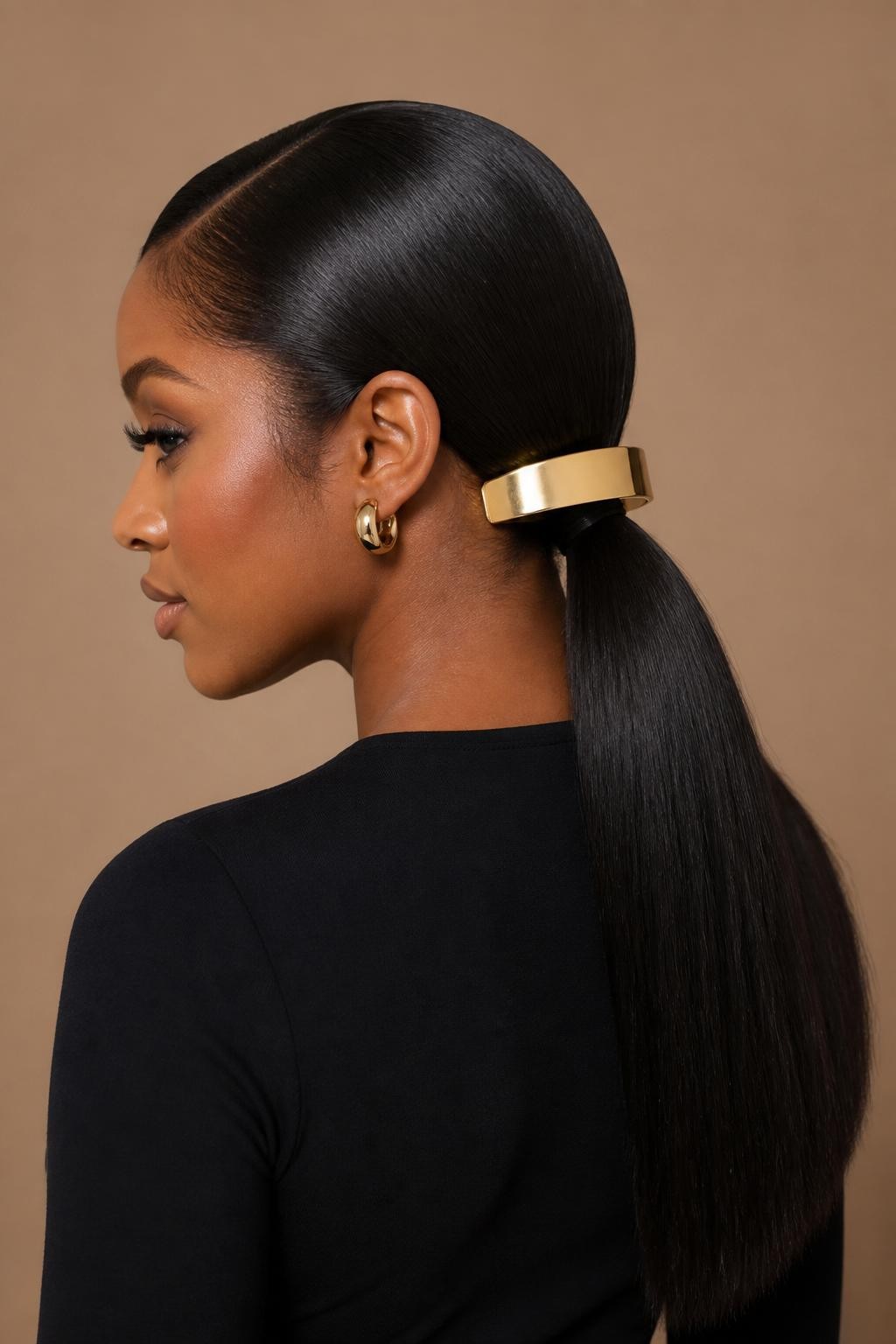 Image Prompt:
A realistic beauty photo of a black woman with medium-long silk-pressed hair styled into a sleek low ponytail, a large gold statement barrette clip placed horizontally above the ponytail base, clean side part, glossy smooth finish, warm brown skin, fitted black top, gold earrings, beige studio background, polished modern hairstyle inspiration, high-resolution DSLR photo, no text, (no watermarks on images)