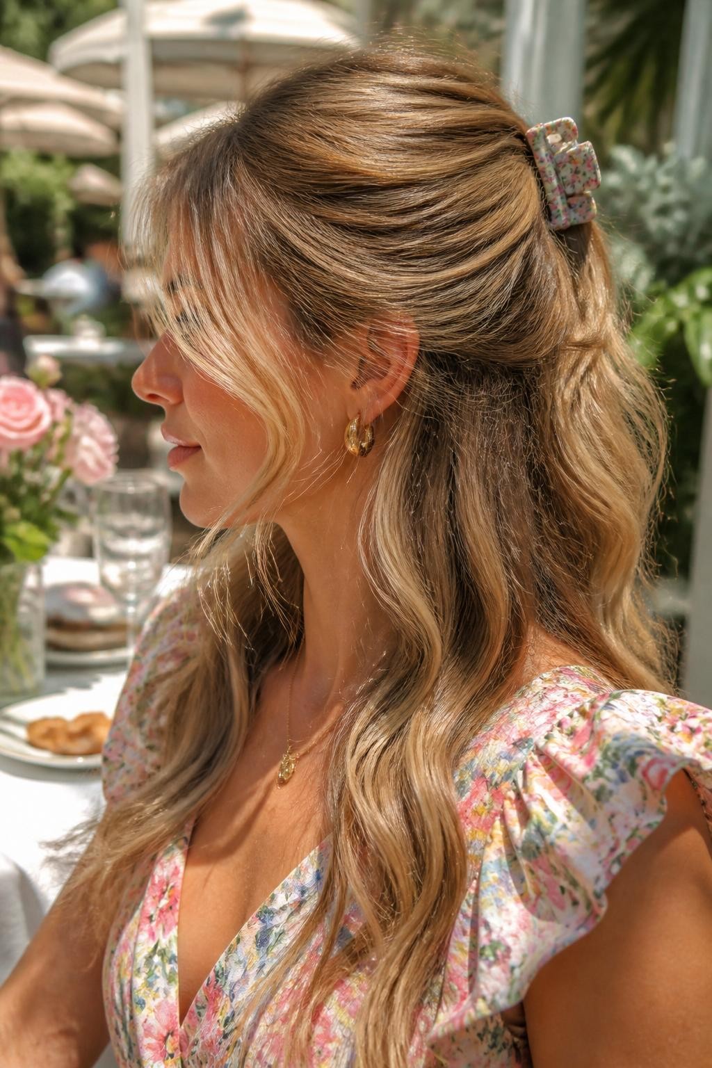 Image Prompt:
A realistic close-up beauty photo of a woman with long sandy blonde hair styled half up half down with a small floral claw clip, loose front pieces curled softly around the cheeks, top hair clipped loosely at the crown, lower hair flowing in relaxed waves, pastel floral dress, outdoor brunch table background, warm sunny light, feminine casual hairstyle inspiration, high-resolution photo, no text, (no watermarks on images)