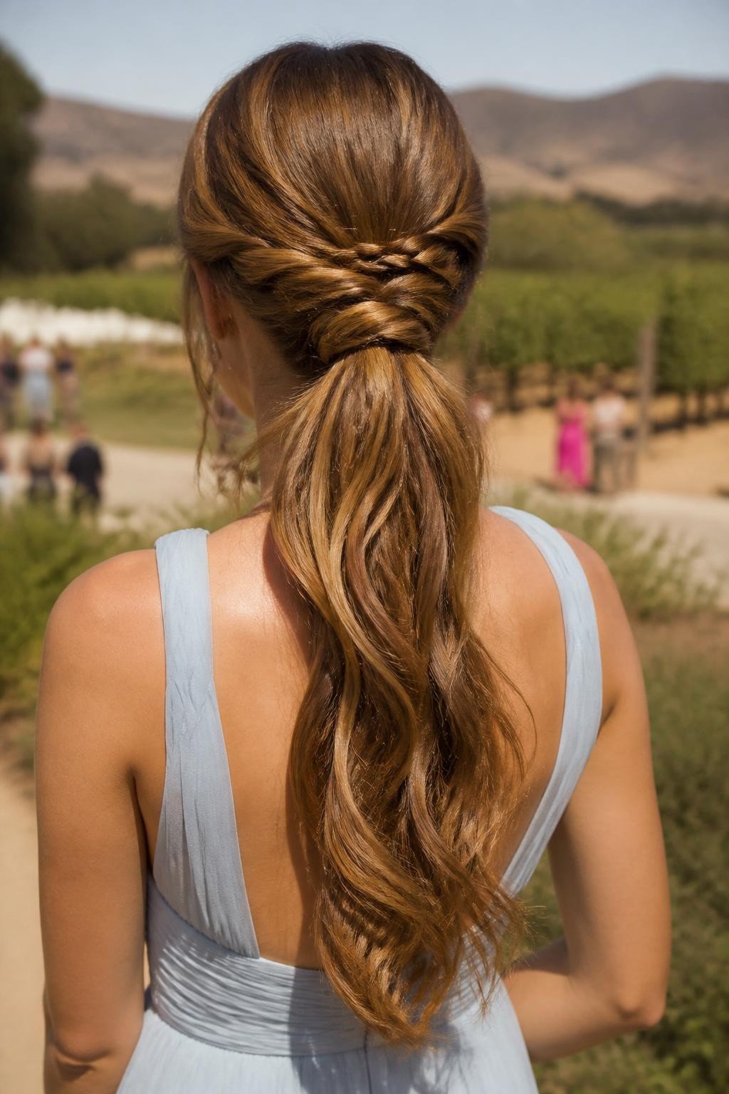 Image Prompt:
A realistic close-up back-view hairstyle photo of a woman with long caramel brown hair styled into a low wedding guest ponytail, one slim side braid wrapped around the ponytail base, loose glossy waves flowing through the ponytail, soft crown volume, pale blue formal dress, outdoor vineyard wedding background, warm natural light, elegant creative ponytail hairstyle inspiration, high-resolution DSLR photography, no text, (no watermarks on images)