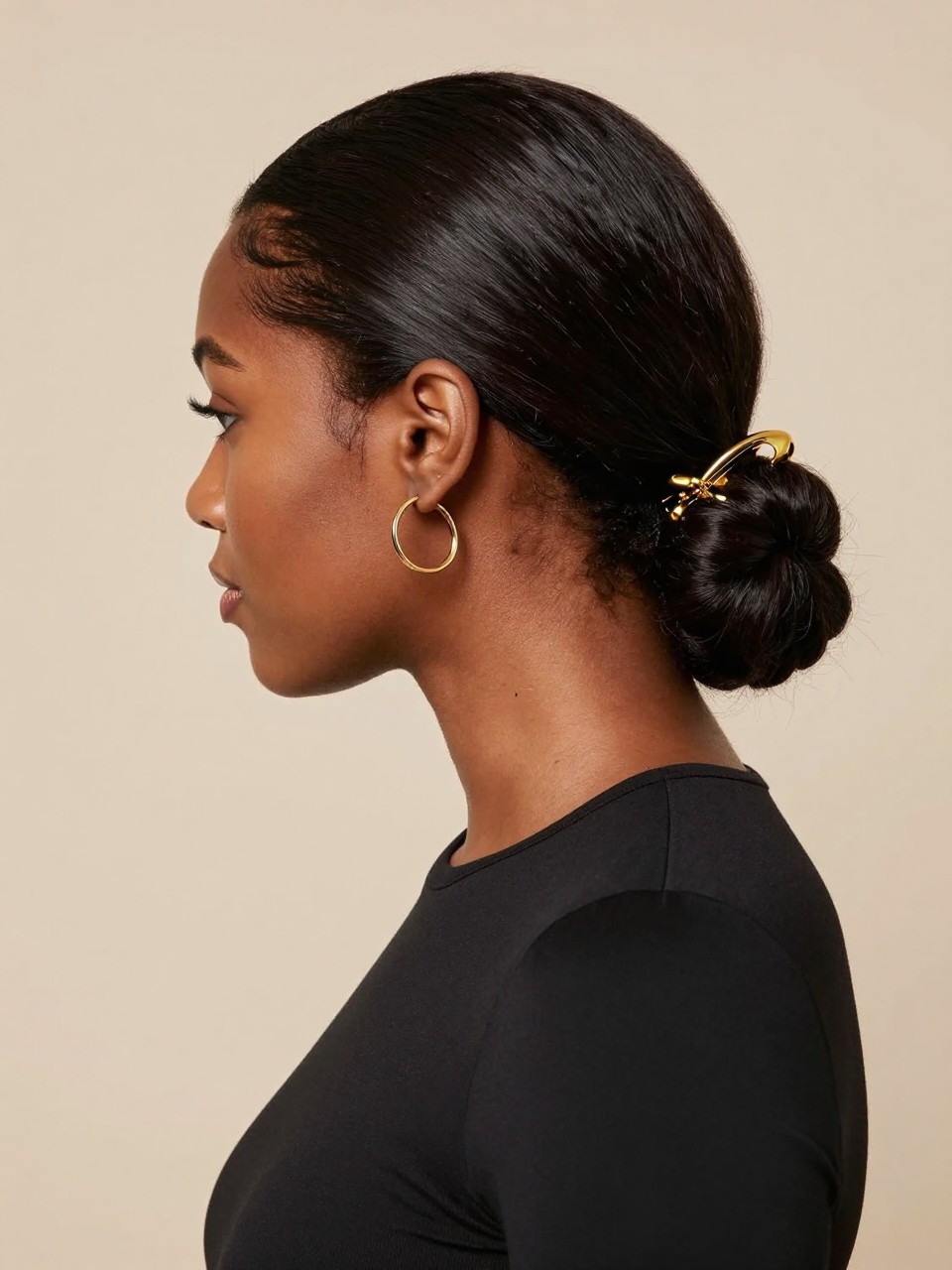 Image Prompt:
A realistic editorial hairstyle photo of a black woman with medium-length silk-pressed hair styled into a sleek low twist secured with a shiny gold claw clip at the nape, deep side part, smooth glossy finish, small hoop earrings, fitted black top, clean beige studio background, polished modern beauty look, high-resolution DSLR photography, no text, (no watermarks on images)