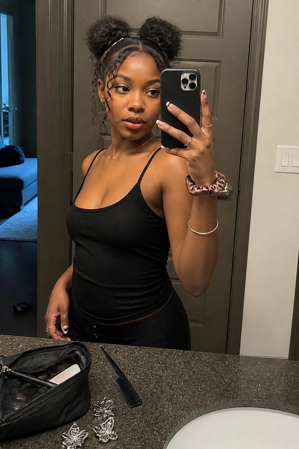 Image prompt
Photo of a Black woman wearing two soft curly space buns with a clean zigzag middle part and loose spiral tendrils around the face, front three-quarter view showing both buns clearly, standing at a bathroom vanity mirror, soft indoor lighting, containing a small lived-in detail such as a rat-tail comb on the counter, silver butterfly clips beside a makeup bag, and a silk scrunchie on her wrist, realistic Y2K getting-ready moment, latest iPhone photo quality.