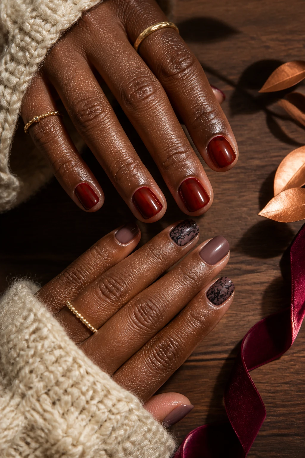 Image Prompt: A realistic top-down manicure photograph showing two complementary Fall 2026 nail trends on a Black woman’s hands with deep brown skin, one hand wearing short rounded translucent cherry-red jelly nails with a glossy syrup-like finish, the other featuring sheer smoky-plum nails with delicate black lace detailing on two accent nails, neat moisturized cuticles, cream knit sleeves, thin gold rings, dark walnut tabletop, small burgundy velvet ribbon and copper leaves nearby, soft golden window light, highly realistic nail, polish, skin, and fabric textures, premium DSLR nail editorial photography, 100mm macro lens, no product logos, no text, no watermarks on images.