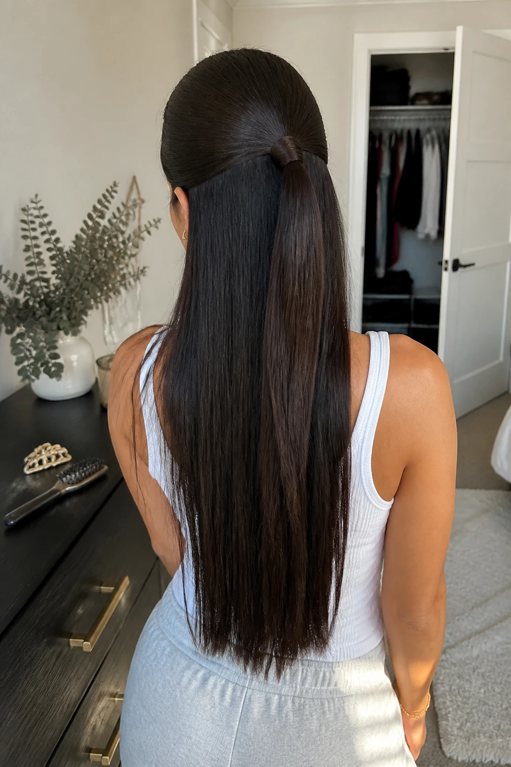 Image prompt

Photo of a woman wearing a smooth half-up straight weave ponytail with long silky lengths and a wrapped hair base, back-of-head view showing the clean sectioning and polished crown, standing in a sun-drenched bedroom, natural window light, containing a small lived-in detail such as a decorative barrette on the dresser, a hairbrush beside it, and a slightly open closet behind her, realistic getting-ready moment, latest iPhone photo quality.